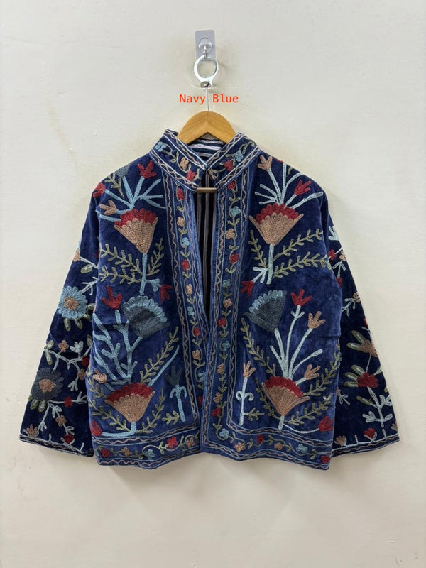Navy blue embroidered jacket on a hanger against a white background