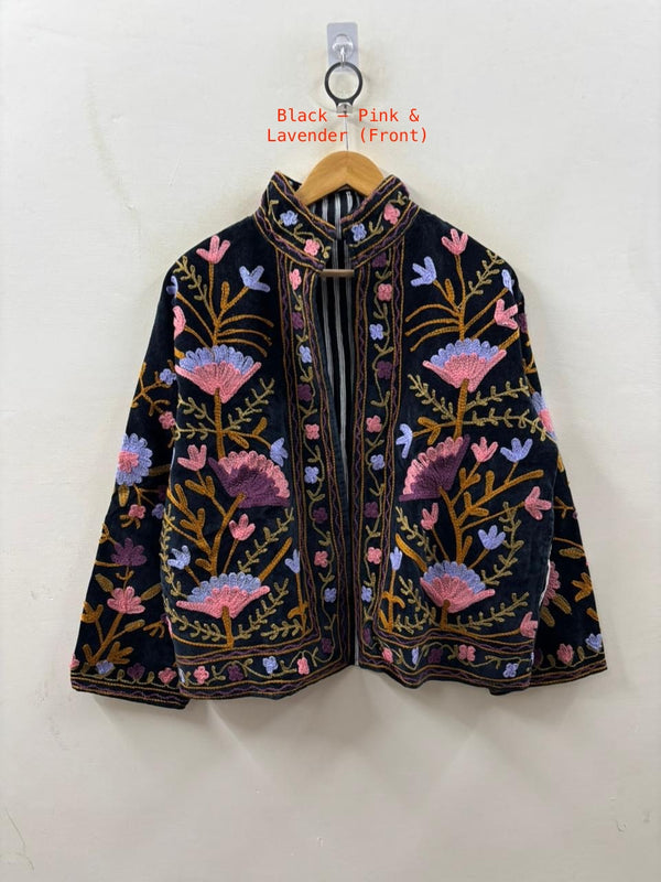Embroidered jacket with floral patterns on a hanger against a white background